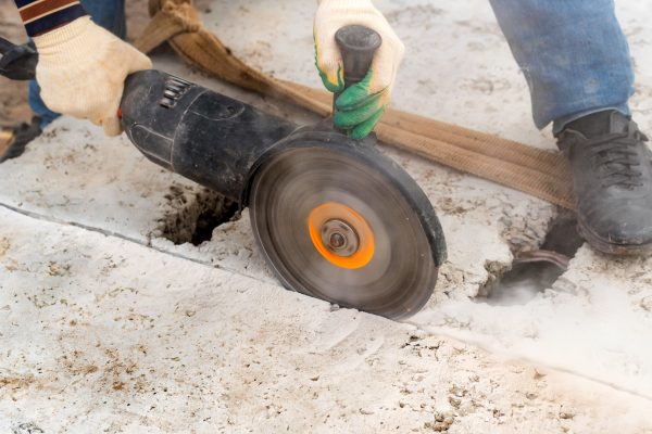 Fragment of a joint cutter on a brushed concrete surface. The diamond disc of a concrete slab cutting machine.